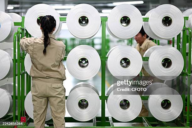 Worker is producing recycled polyester filament in the digital production workshop of Jiangsu Ruibang Technology Co., Ltd. In Siyang County, Suqian...