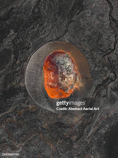 abstract drone image looking down on a volcanic crater surrounded by a lava plain, lanzarote, canary islands, spain - cinder cone volcano stock pictures, royalty-free photos & images