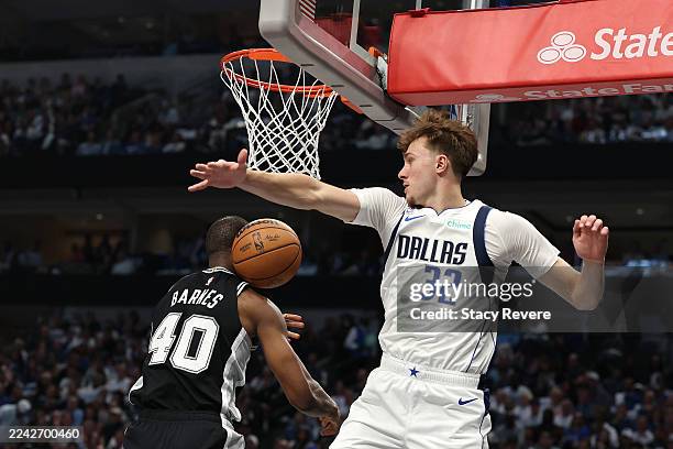 Harrison Barnes of the San Antonio Spurs is defended by Cooper Flagg of the Dallas Mavericks during the first half at American Airlines Center on...