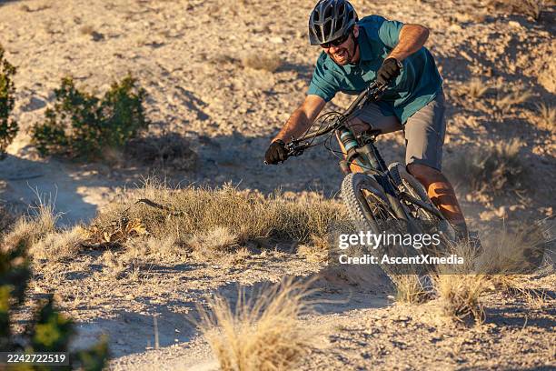 mountain biker rides trail in desert - mountain biking stock pictures, royalty-free photos & images