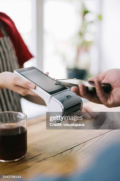 contactless payment transaction using smartphone at cafe with glass of coffee - convenience stock pictures, royalty-free photos & images