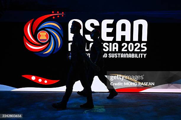 Members of the Royal Malaysia Police walk next to the Association of Southeast Asian Nations logo ahead of the 47th ASEAN Summit in Kuala Lumpur on...