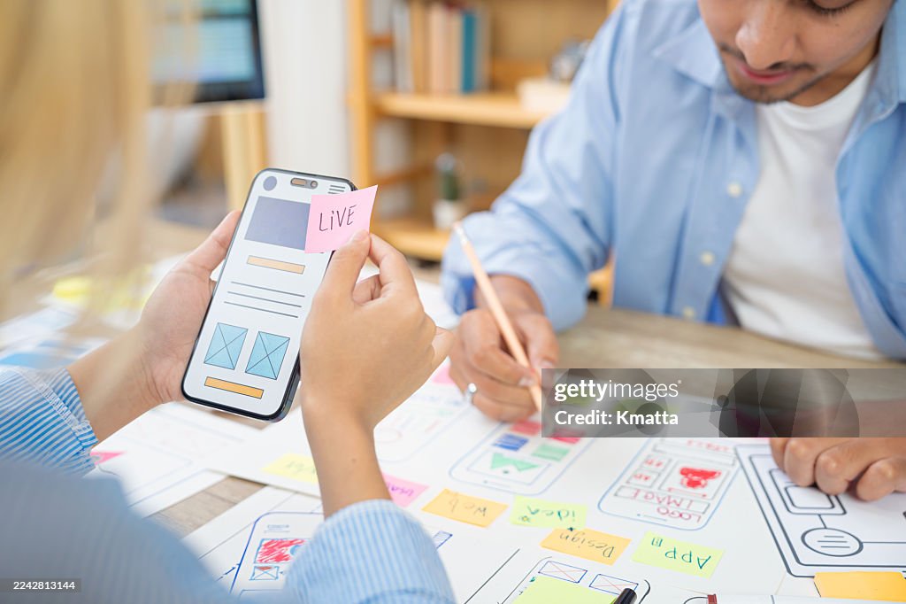 Team developing mobile app ui prototype with live sticky note.