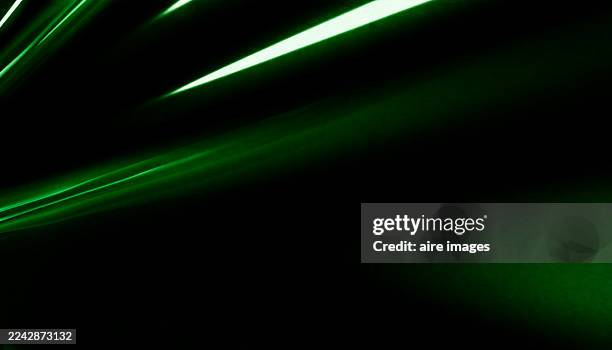 green neon lines abstract background with light trails - rastros de luz fotografías e imágenes de stock