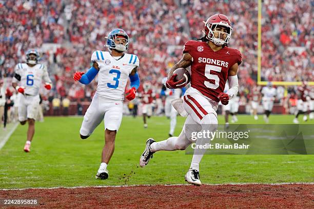 Wide receiver Isaiah Sategna III of the Oklahoma Sooners scores a 76-yard touchdown off a 10-yard catch against safety Sage Ryan and linebacker TJ...