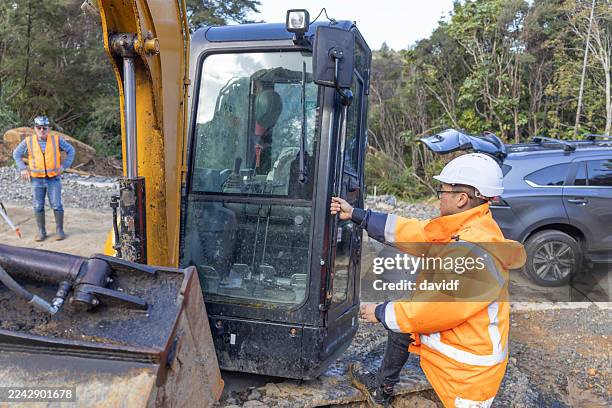 trabajador de la construcción con equipo pesado de movimiento de tierras - movimiento de tierras fotografías e imágenes de stock