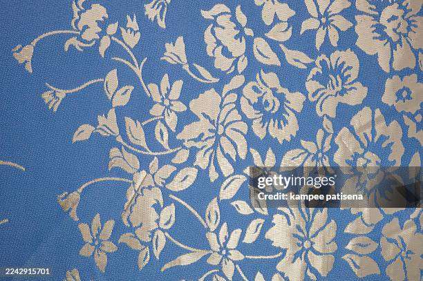 a silver floral patterned fabric with blue background - stoffmuster stock-fotos und bilder