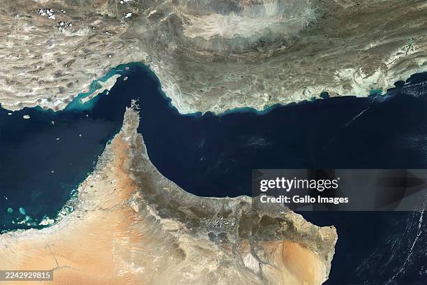Satellite view of the Strait of Hormuz, a critical chokepoint for global energy supply, connecting the Persian Gulf to the Gulf of Oman. This vital...