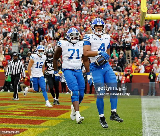 Running back LJ Martin of the BYU Cougars celebates with teammates Ikinasio Tupou and Preston Rex of the BYU Cougars after scoring a touchdown in the...