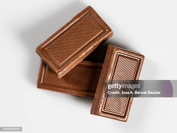 close-up of three bars of chocolates in small individual bars on a white background. - milk chocolate stock pictures, royalty-free photos & images