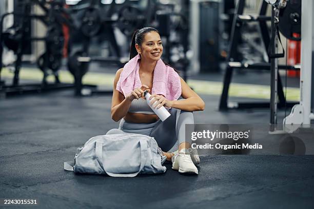 frau, die nach dem training im fitnessstudio eine pause einlegt - sporttasche stock-fotos und bilder