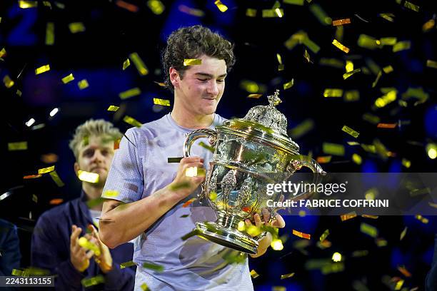 Brazil's Joao Fonseca raises the trophy after winning against Spain's Alejandro Davidovich Fokina in their men's final match at the Swiss Indoors ATP...