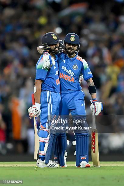 Rohit Sharma of India is congratulated by teammate Virat Kohli after completing a century during game three of the One Day International series...