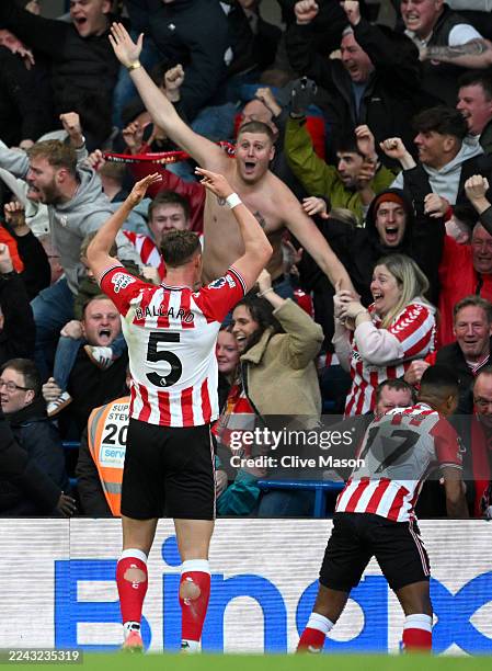 Daniel Ballard and Reinildo Mandava of Sunderland celebrate their team's second goal with the fans during the Premier League match between Chelsea...