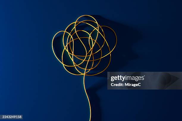 yellow string tangled knot on blue background - intrication photos et images de collection