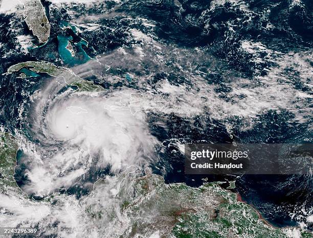 In this handout satellite image provided by the National Oceanic and Atmospheric Administration , Hurricane Melissa churns northwest through the...