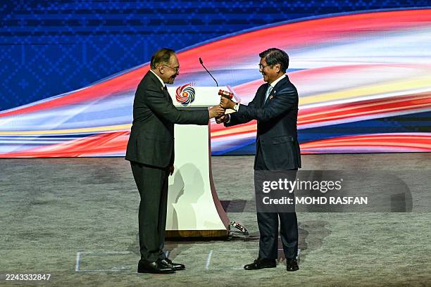 Philippines' President Ferdinand Marcos Jr is given the ceremonial gavel by Malaysia's Prime Minister Anwar Ibrahim during the ASEAN chairmanship...