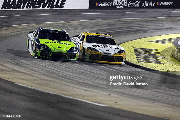 Taylor Gray, driver of the Operation 300 Toyota, and Aric Almirola, driver of the Young Life Toyota, race during the NASCAR Xfinity Series IAA and...