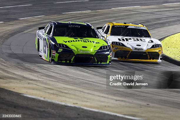 Taylor Gray, driver of the Operation 300 Toyota, and Aric Almirola, driver of the Young Life Toyota, race during the NASCAR Xfinity Series IAA and...