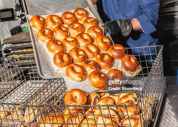 Worker places plain bagels into a bin at a PopUp Bagels location in the Upper West Side neighborhood of New York, US, on Thursday, Oct. 9, 2025....