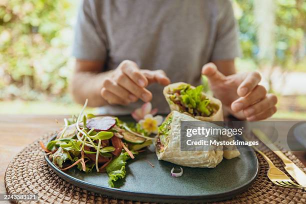 mann greift nach gesundem wrap und salatteller - glutenfrei stock-fotos und bilder