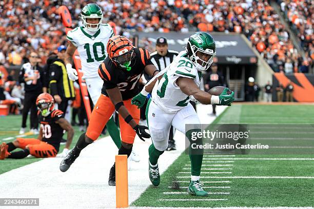 Breece Hall of the New York Jets carries the ball for a touchdown defended by Jordan Battle of the Cincinnati Bengals during the fourth quarter in...