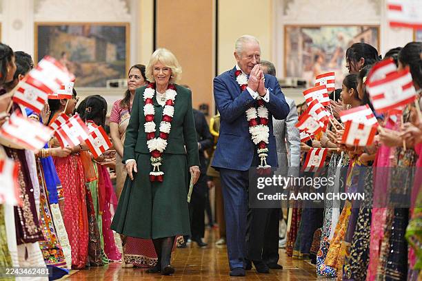 Britain's King Charles III and Britain's Queen Camilla are greeted by children as they arrive for a visit the BAPS Shri Swaminarayan Mandir, more...