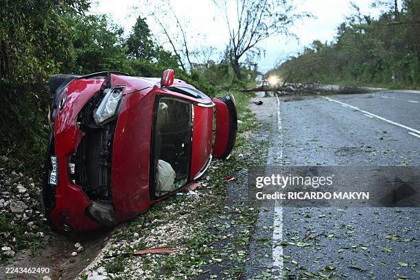 Damaged car by a fallen tree is seen after the passage of Hurricane Melissa in Manchester, Jamaica, on October 29, 2025. Hurricane Melissa ripped up...