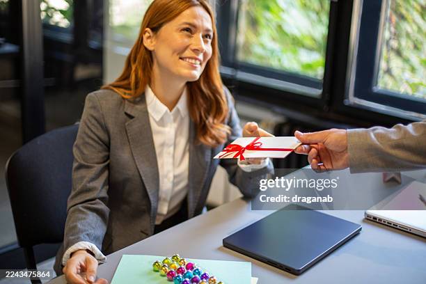 employee receiving bonus gift card in office - perks stock pictures, royalty-free photos & images