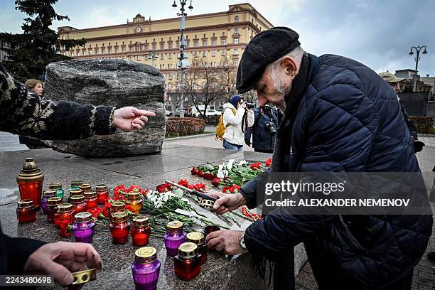 Man lights candles at the monument for the victims of political repressions in front of the FSB security service headquarters in Moscow on October...