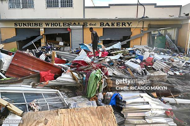 Young man walks on the rubble left on the street following the passage of Hurricane Melissa, in Black River, Jamaica on October 29, 2025. Hurricane...