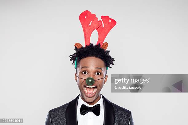 funny christmas portrait of happy elegant man wearing reindeer headband hores - antler stock pictures, royalty-free photos & images