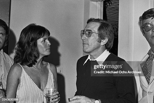 Franco-American singer and actress Claudine Longet, wearing a light-coloured sleeveless V-neck dress and her husband, American singer Andy Williams,...