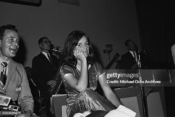 Franco-American singer and actress Claudine Longet, wearing a dark-coloured short-sleeve outfit with light-coloured trim, attends an event during the...