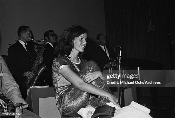 Franco-American singer and actress Claudine Longet, wearing a dark-coloured short-sleeve outfit with light-coloured trim, attends an event during the...