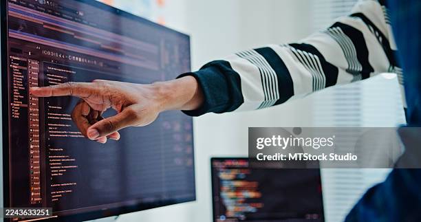 closeup of two male software developers meeting on multiple computer screens displaying programming code, collaborating on project in office. artificial intelligence and programming. - python data stock pictures, royalty-free photos & images