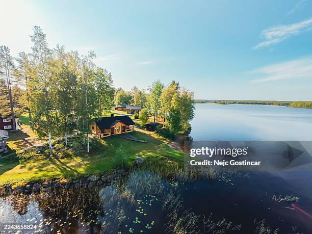 aerial view of a traditional log house by a finnish lake surrounded by forest - chalet stock pictures, royalty-free photos & images