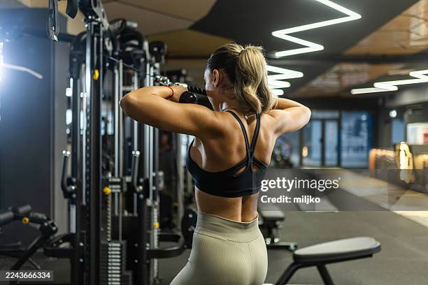 mujer en forma haciendo ejercicio en máquina de cable - centro de bienestar fotografías e imágenes de stock