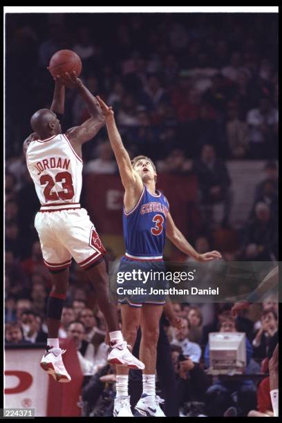 Guard Michael Jordan of the Chicago Bulls takes a shot during a game against the Cleveland Cavaliers at the United Center in Chicago, Illinois....