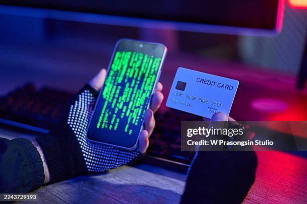 hacker holding smartphone with code and credit card - robber gloves stock pictures, royalty-free photos & images