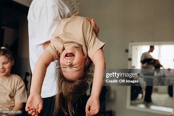 father holding carefree daughter at home - belarus stock pictures, royalty-free photos & images