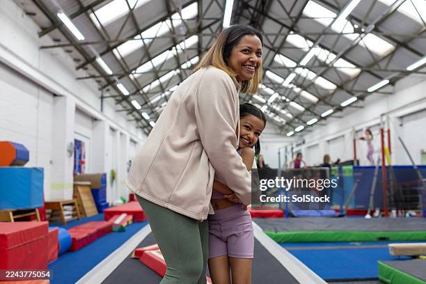 mother and daughter hugging in gymnastics hall - gymnast stock pictures, royalty-free photos & images