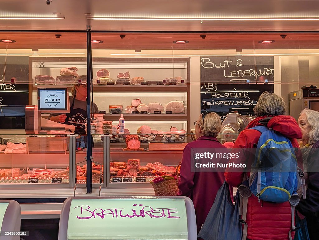 Customers Queue At Gourmet Butcher Meat Stall On Market