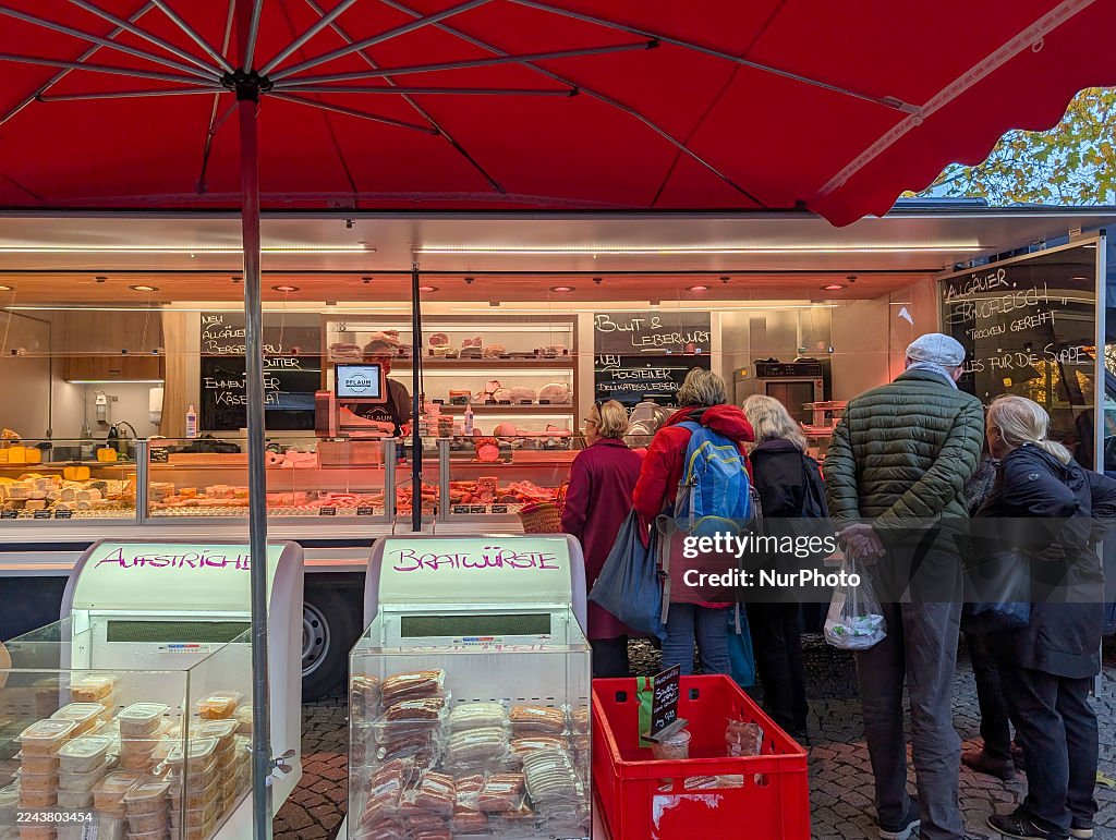 Customers Queue At Gourmet Butcher Meat Stall On Market