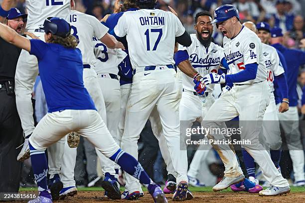 Freddie Freeman of the Los Angeles Dodgers celebrates at home plate with teammates after hitting a walk-off home run during the 18th inning against...