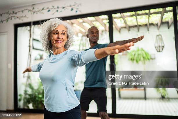 amerikanische seniorin macht yoga mit ehemann zu hause - weißes haar stock-fotos und bilder