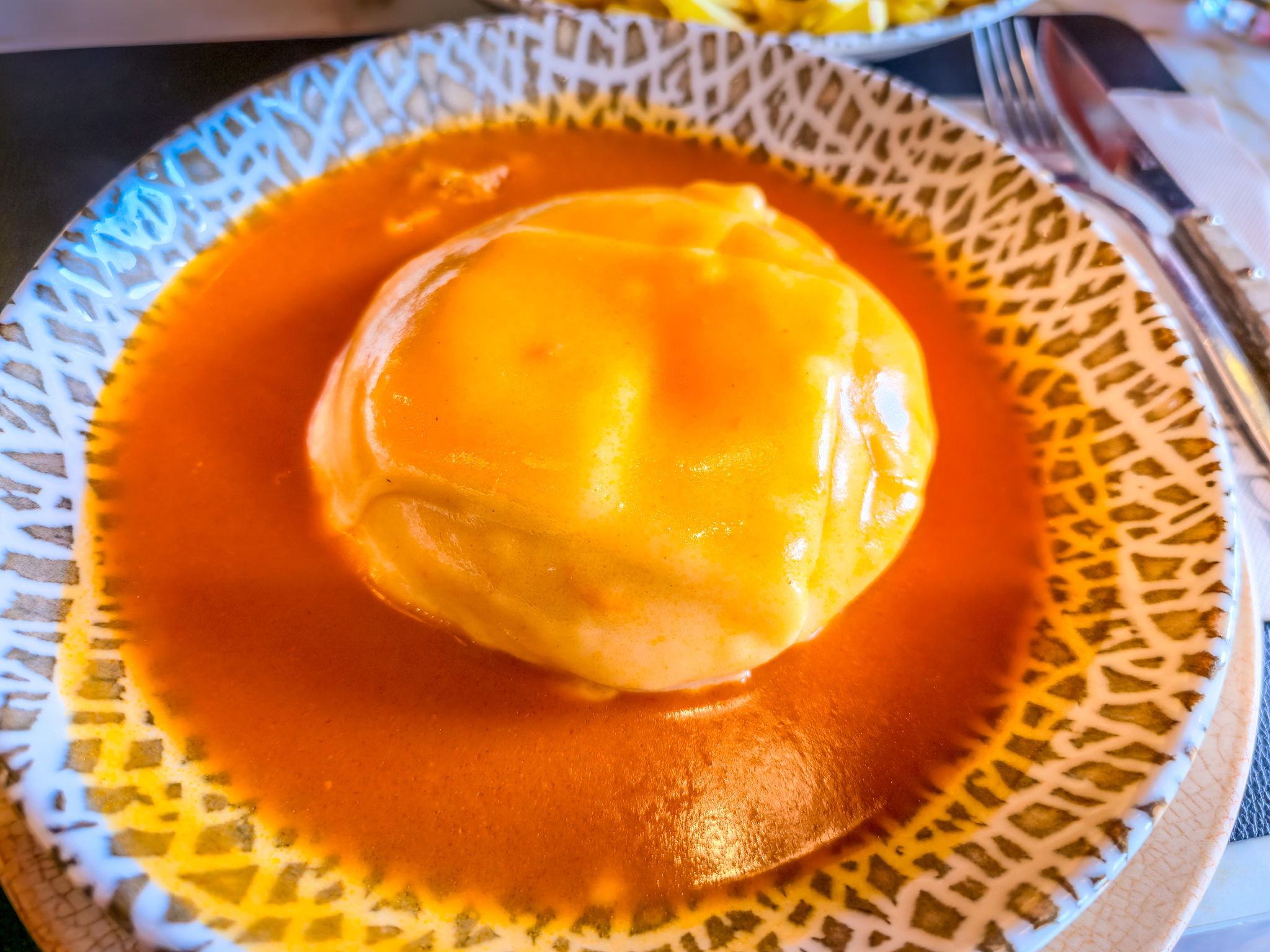 Typical sandwich from Porto know as francesinha. It's made with toasted bread and assorted hot meats over which sliced cheese is melted by the ladling of a near-boiling tomato-and-beer sauce. Typical sandwich from Porto know as francesinha. It's made with toasted bread and assorted hot meats over which sliced cheese is melted by the ladling of a near-boiling tomato-and-beer sauce.