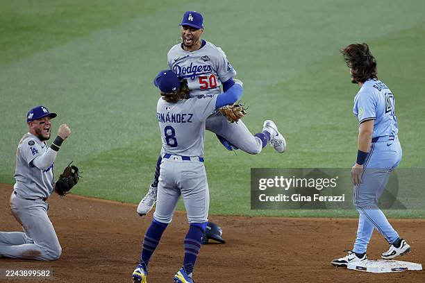 Toronto, Ontario, Canada October 31, 2025: Los Angeles Dodgers shortstop Mookie Betts leaps to Los Angeles Dodgers first baseman Enrique Hernandez...
