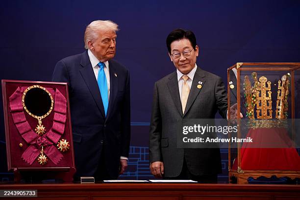 President Donald Trump reacts as he is presented with the Grand Order of Mugunghwa and the Silla gold crown by South Korean President Lee Jae Myung...