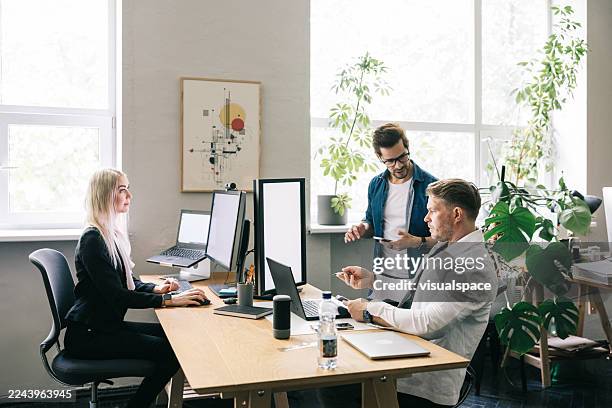 creative professionals collaborating in a modern office with natural lighting and plants - open plan stock pictures, royalty-free photos & images